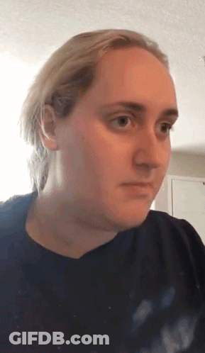 Blonde Woman In Black Shirt Looking At Camera GIF