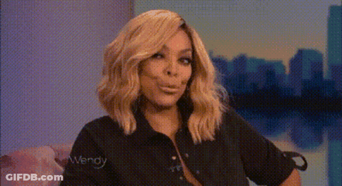 Blonde Woman In Black Shirt Making Funny Face On Couch GIF