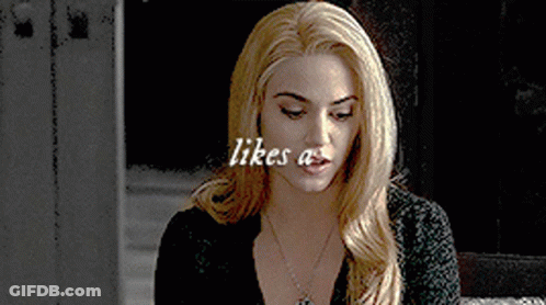 Blonde Woman In Black Shirt With Necklace Saying Likes A GIF