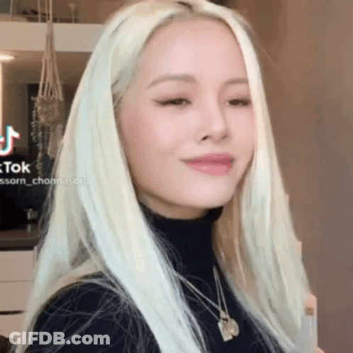 Blonde Woman In Black Turtleneck And Necklace GIF