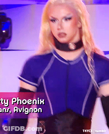 Blonde Woman In Blue Shirt And Black Gloves In Front Of Phoenix And Avignon Sign GIF