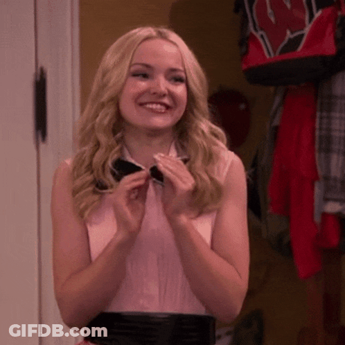 Blonde Woman In Bow Tie And Pink Shirt Smiles GIF