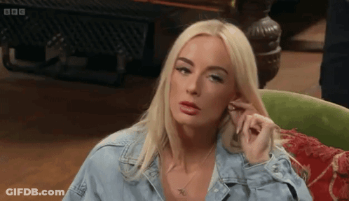 Blonde Woman In Denim Shirt Sitting In Green Chair GIF