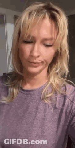 Blonde Woman In Purple Shirt Looking Down GIF