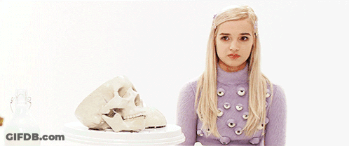 Blonde Woman In Purple Sweater Next To Skull GIF