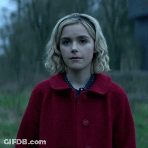 Blonde Woman In Red Coat And Headband Smiling GIF