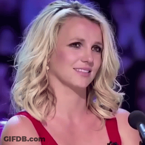 Blonde Woman In Red Dress Smiling At Microphone GIF