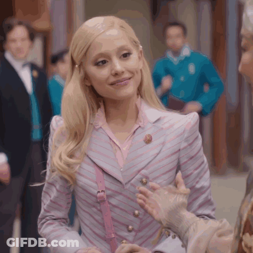Blonde Woman In Striped Jacket And Pink Purse Smiling GIF