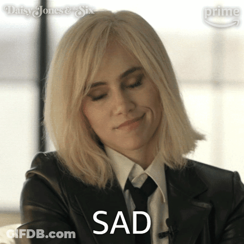 Blonde Woman In Suit And Tie Says Sad GIF