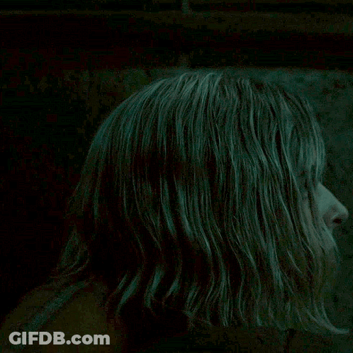 Blonde Woman Looking At Camera In Dark Room GIF