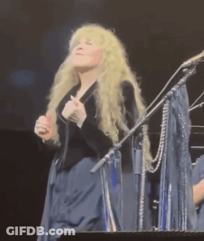 Blonde Woman Singing Into Microphone On Stage GIF