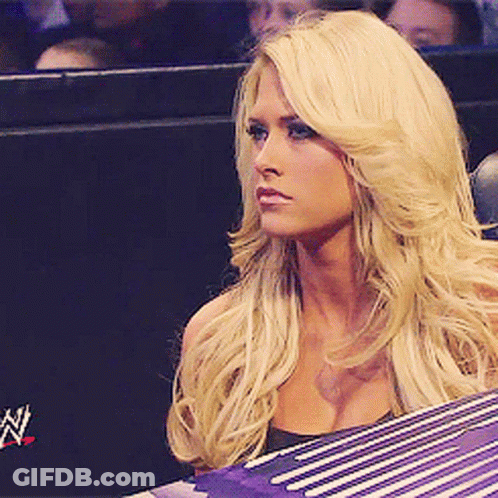 Blonde Woman Sitting In Front Of Wrestling Ring GIF