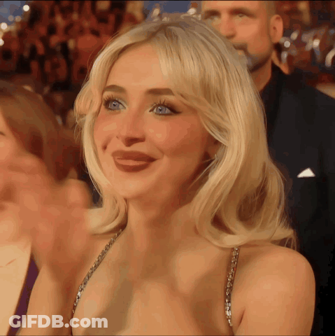 Blonde Woman Smiling In Crowd GIF