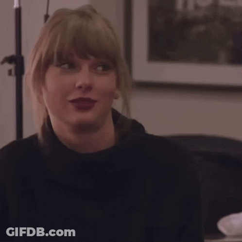 Blonde Woman Smiling In Front Of A Picture GIF