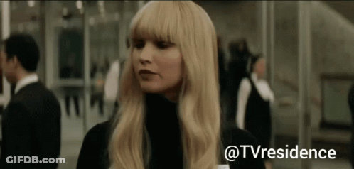 Blonde Woman Standing In Front Of Glass Wall GIF