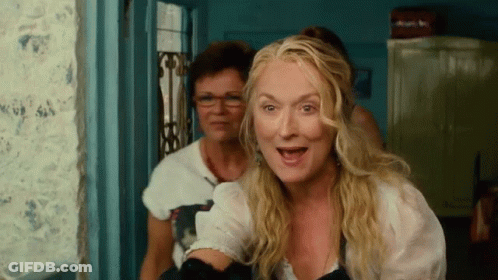 Blonde Woman With Glasses Standing Next To Another Woman GIF