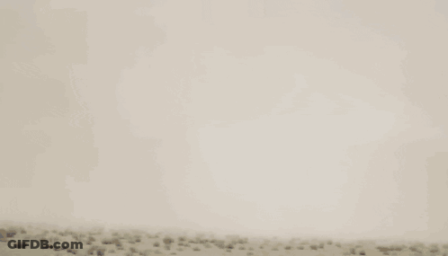 Blue And Red Robot Flying Through Cloudy Sky GIF