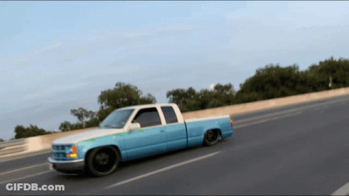 Blue And White Truck Driving Down Road GIF