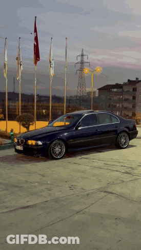 Blue BMW Parked With Flags GIF
