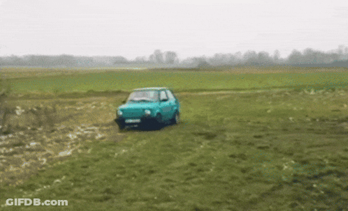 Blue Car Driving Through Grassy Field GIF