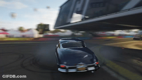 Blue Car Driving Under Bridge With Building GIF
