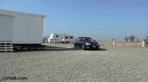 Blue Car Parked In Gravel Lot GIF
