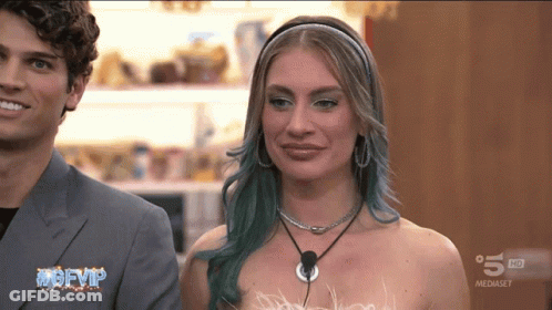 Blue Hair Woman Next To Man TV Saying Mgfvip GIF