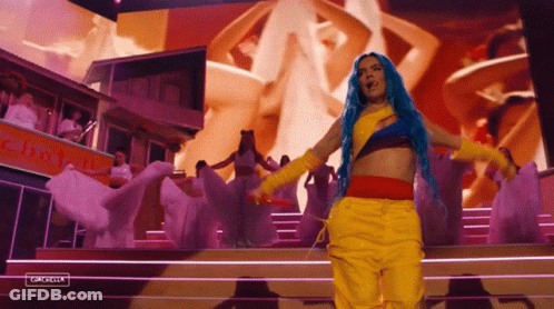 Blue-Haired Woman In Yellow Pants On Stage GIF