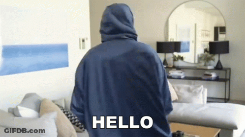 Blue Hoodie Man Standing With Couch And Mirror GIF