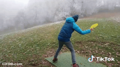 Blue Jacket Man Throwing Frisbee Green Mat TikTok Watermark GIF