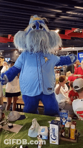 Blue Mascot In Front Of Calcium Box GIF
