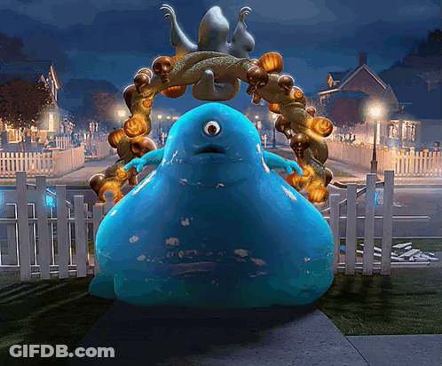 Blue Monster Standing In Front Of Fence With Pumpkins GIF