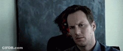 Blue Shirt Man Sitting In Front Of Demon Painting GIF