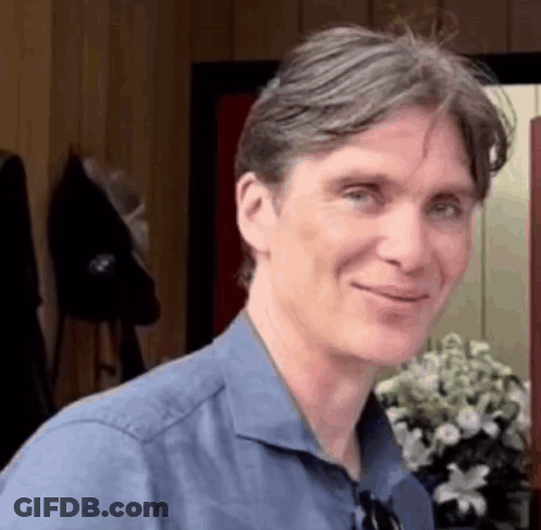 Blue Shirt Man Smiling With Vase Of Flowers GIF