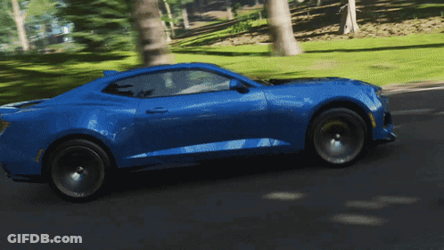 Blue Sports Car Driving Down Road Through Trees GIF