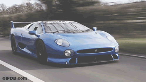 Blue Sports Car Driving Down Road With Trees GIF
