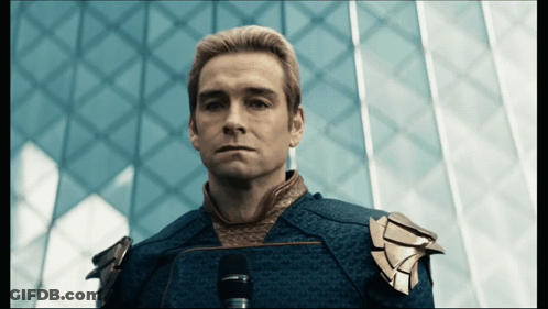 Blue Suit Man Staring At Camera Dark Room GIF