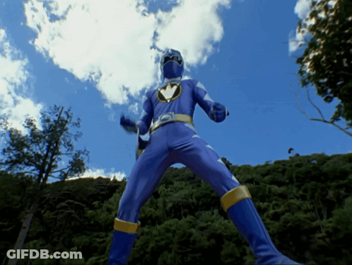 Blue Superhero Standing In Front Of Trees GIF