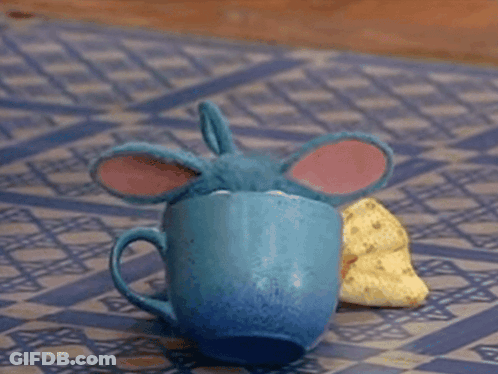 Blue Toy Sitting On Checkered Mat Eating Banana GIF