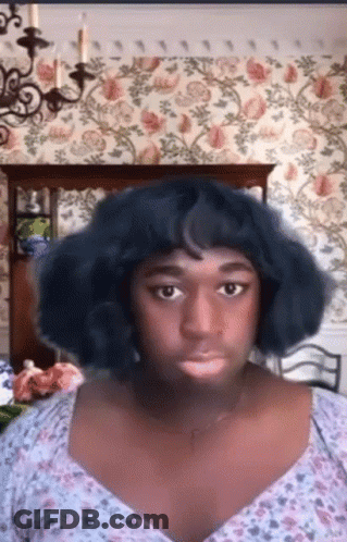Blue Wig Floral Top Woman Looking At Camera GIF