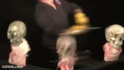 Blurred Person Holding Tray In Front Of Skulls GIF