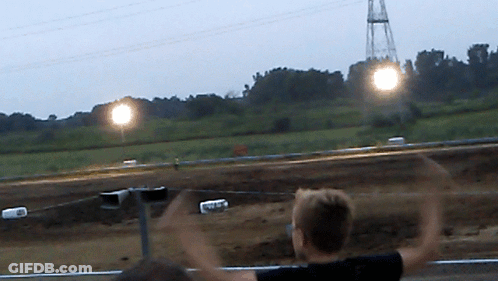 Blurred Person Watching Race With Arms Up GIF
