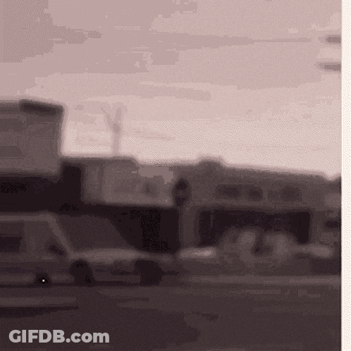 Blurred Street With Sign Saying A GIF