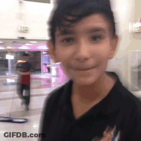 Blurry Boy In Black Shirt With Pink Exit Sign GIF