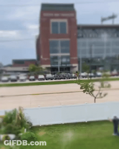 Blurry Brick Building With Parked Cars GIF