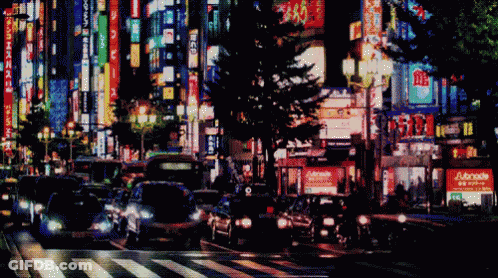 Blurry City Street At Night With Adonis Sign GIF