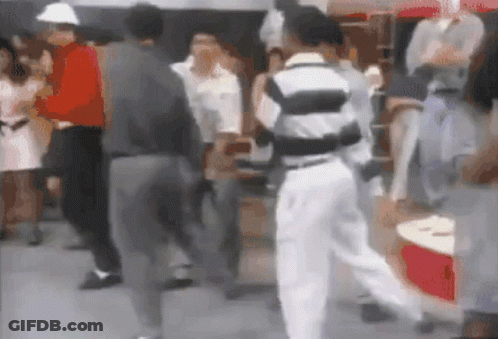 Blurry Group Of People Dancing In Front Of Red Cooler GIF