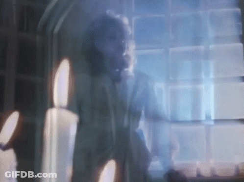 Blurry Man At Window With Candles GIF