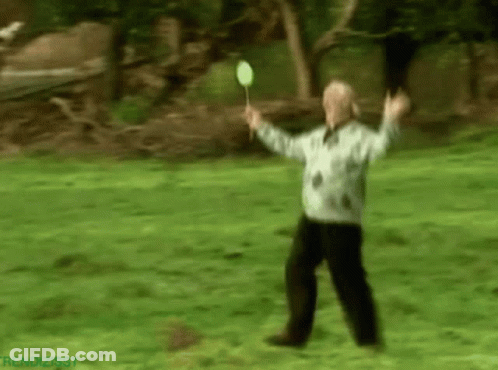 Blurry Man Holding Badminton Racket In Park GIF