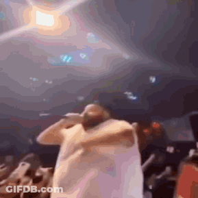 Blurry Man Holding Microphone In Front Of Crowd GIF